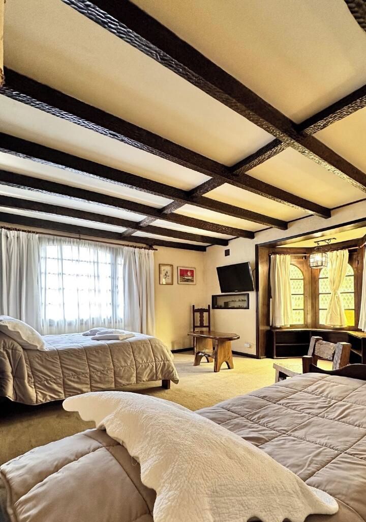 Una habitación con una cama, una silla, una mesa y un televisor.