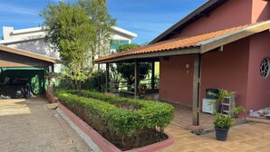 Ein Wohngebiet mit gepflasterter Auffahrt, überdachter Terrasse und gepflegtem Garten.