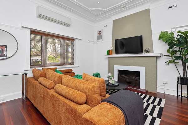 Your ultimate chill zone awaits! This bright, modern living room boasts a huge, comfy sectional, a fireplace, and air conditioning for perfect relaxation.