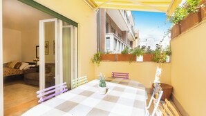 A small outdoor patio with a checkered table, a bench, and potted plants. - Rental in Rome Annietta Apartment (Rome)