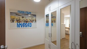 A hallway with a poster of Federico Fellini and Amarcord, a mirrored wardrobe, and a glimpse of a bathroom. - Rental in Rome Annietta Apartment (Rome)