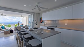 Een moderne keuken met een centraal eiland, een bar en uitzicht op de oceaan.