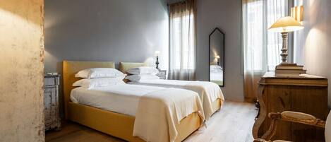 A room with a bed, a chair, a lamp, and a mirror.