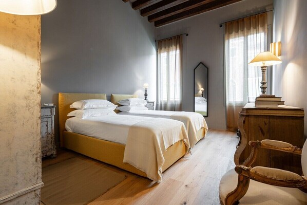 Una habitación con cama, una silla, una lámpara y un espejo.