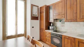 A kitchen with wooden cabinets, a stove, and a microwave.