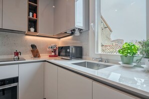 A modern kitchen with a built-in oven, a microwave, and a sink.