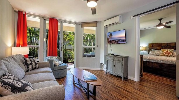 Una sala de estar moderna con un sofá, una mesa de centro y un televisor montado en la pared.
