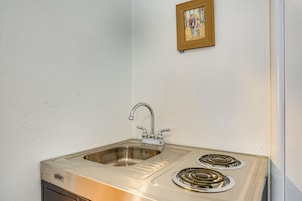 Cocina con pileta de acero inoxidable y dos hornillas.