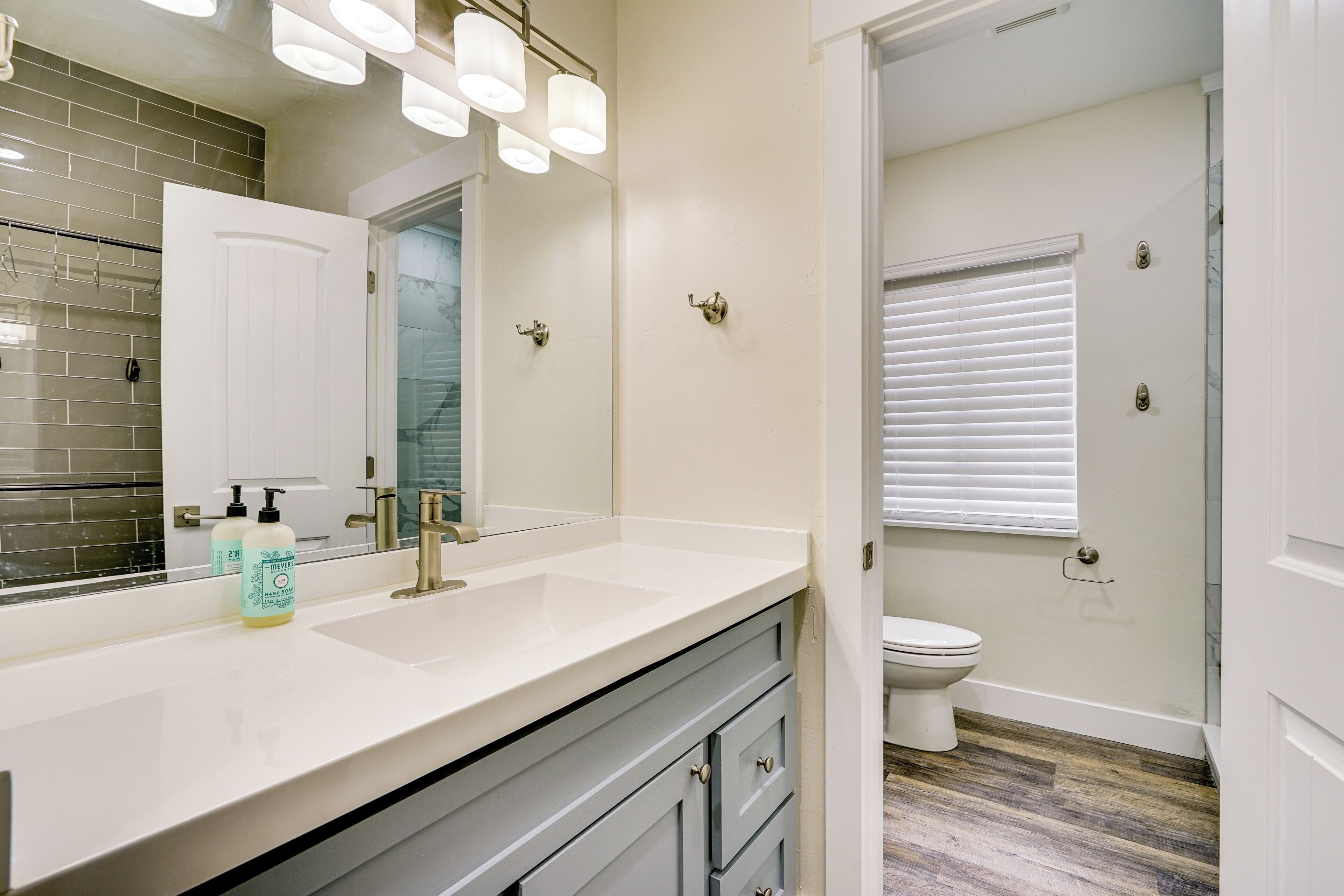 A bathroom with a white sink, a mirror, and a toilet.