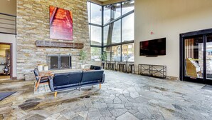 A spacious lobby with a stone wall, a fireplace, a large window, and a seating area. - 2 Mi to the Slopes! Park City Condo w/ Hot Tub (Park City)