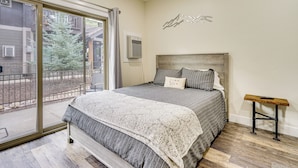 A bedroom with a large bed, a wooden headboard, a small table, and a view of a building outside. - 2 Mi to the Slopes! Park City Condo w/ Hot Tub (Park City)