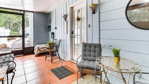 A covered patio area with a dining table, chairs, and a potted plant. - Screened Porch: Tampa Studio 4 Mi to Busch Gardens (Tampa)