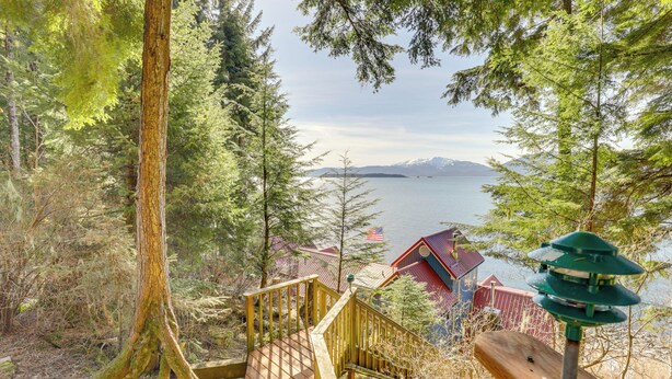 Una escalera de madera que conduce a una cabaña con vistas a un lago y montañas.