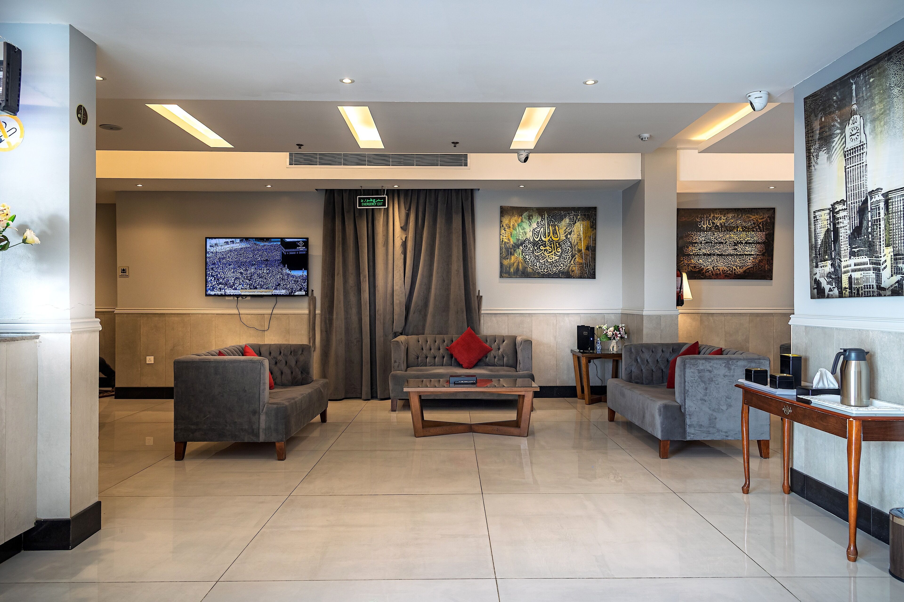 A modern lobby with a flat-screen TV, comfortable seating, and artwork on the walls.