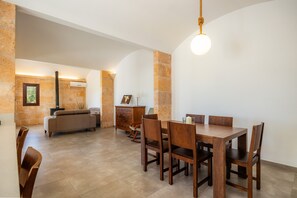 Ein Essbereich mit Holztisch und -stühlen, einer Couch und einem Kamin.