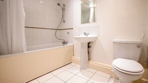 A bathroom with a bathtub, sink, and toilet. - Kensington & Earls Court 1 bed Apartment - 4 Guest (London)