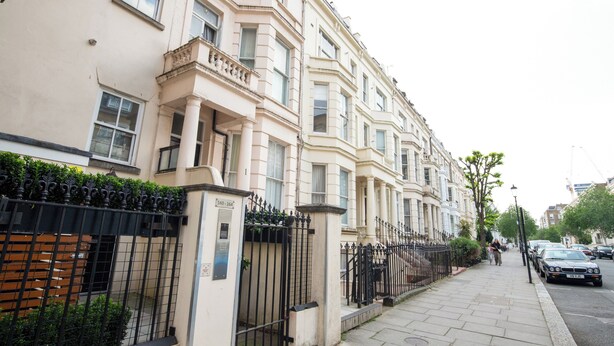 A row of traditional European townhouses with a black wrought-iron fence and a paved sidewalk. - Kensington & Earls Court 1 bed Apartment - 4 Guest (London)