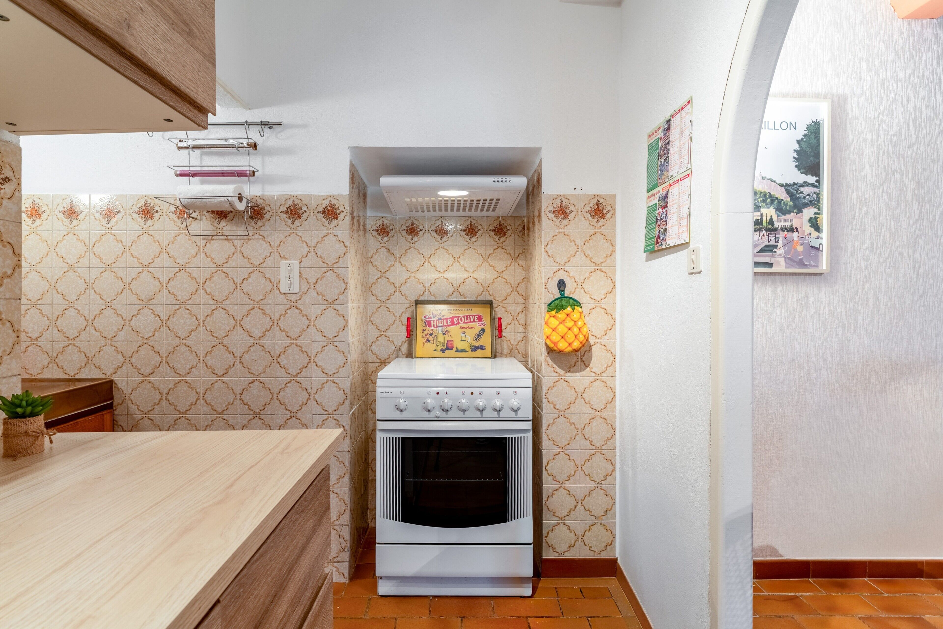 Una cocina con horno empotrado, encimera de madera y azulejos con diseño.