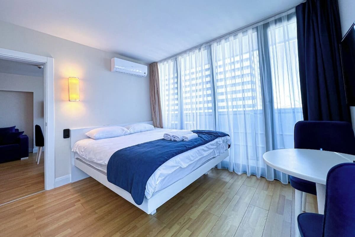 A hotel room with a bed, a table, and a chair.