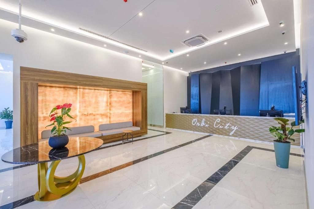 Zona de recepción de un hotel con mostrador, área de estar y diseño moderno.