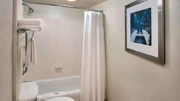 A bathroom with a bathtub, toilet, and a shower curtain.