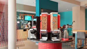 A breakfast bar with various food dispensers, including a Total Raisin Bran and Lucky Charms. - Candlewood Suites Mission East Mcallen Area by IHG (Mission)