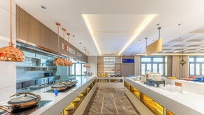Een moderne hotellobby met een lange receptiebalie, glazen vitrines en een centrale zithoek.