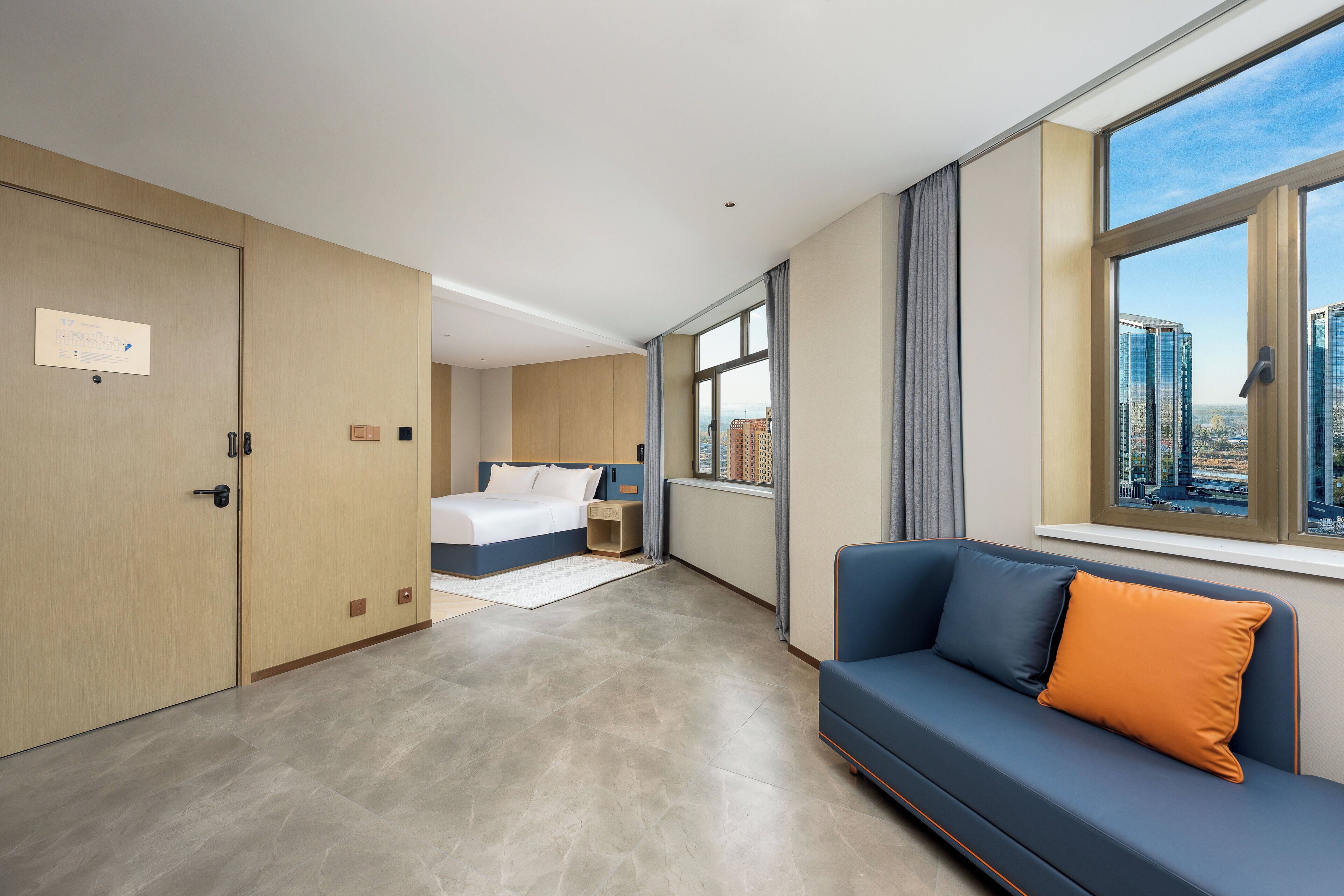 Une chambre d’hôtel moderne avec un grand lit, un canapé et une vue sur la ville.
