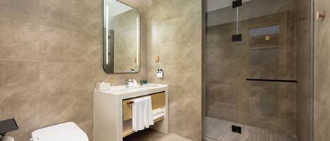 Un baño moderno con inodoro, lavabo y ducha.