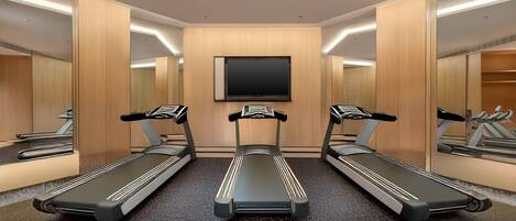 Een sportschool met drie loopbanden, houten wanden, een grote spiegel en een flatscreen televisie aan de muur.