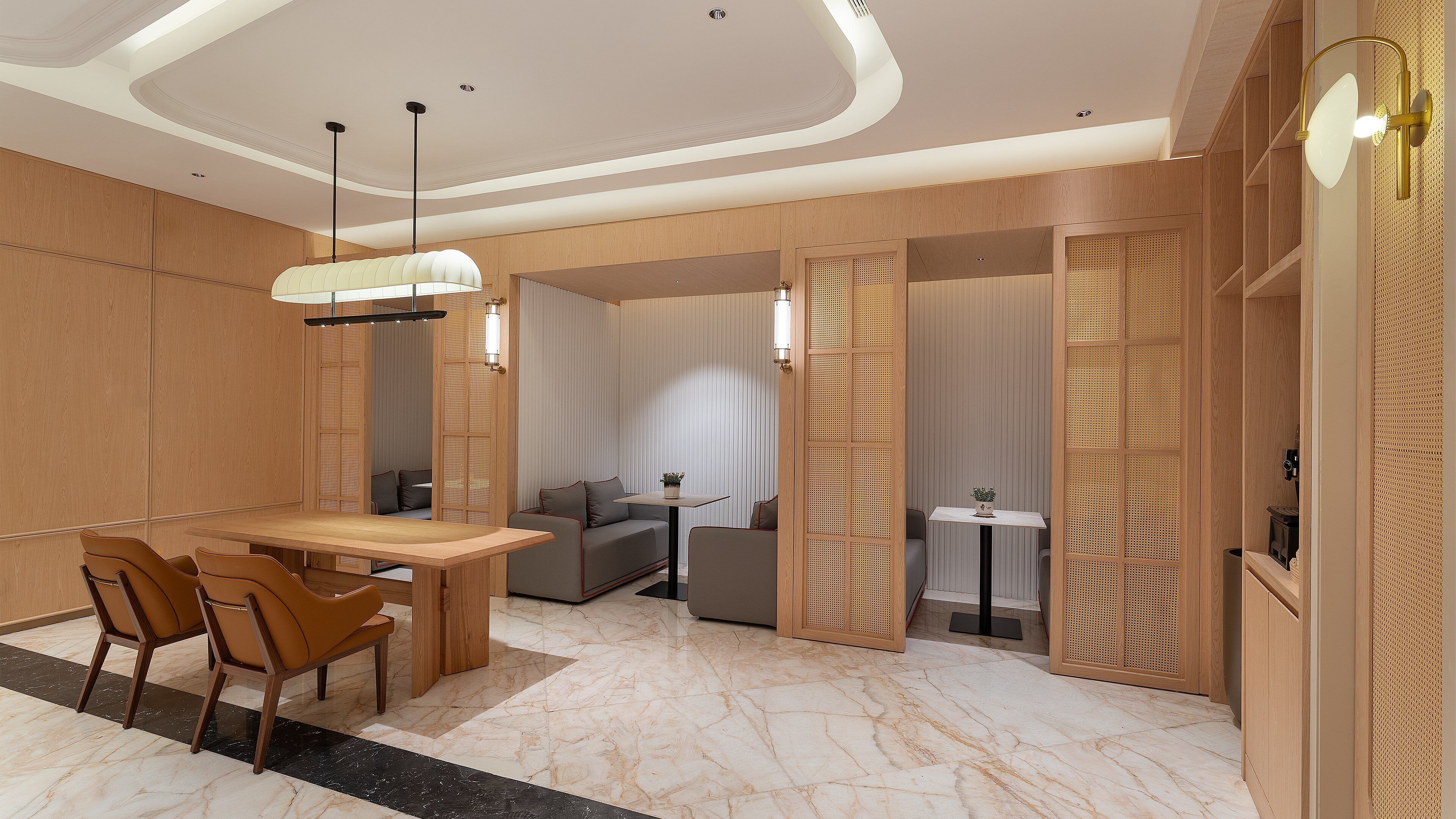 Habitación de hotel moderna con zona de comedor, un sofá y una pequeña mesa con una planta.