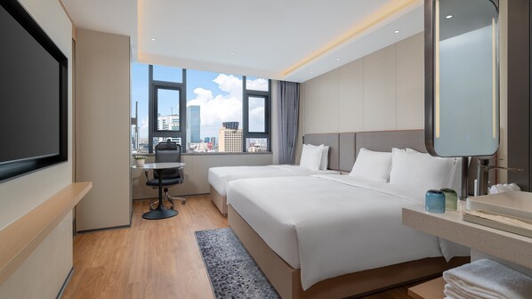 A modern hotel room with a large bed, a desk, and a view of the city skyline. - Holiday Inn Express Kunming Railway Station by IHG (Kunming)
