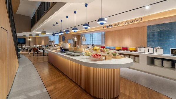 En modern frukostbar med ett varierat utbud av mat och en kaffestation.