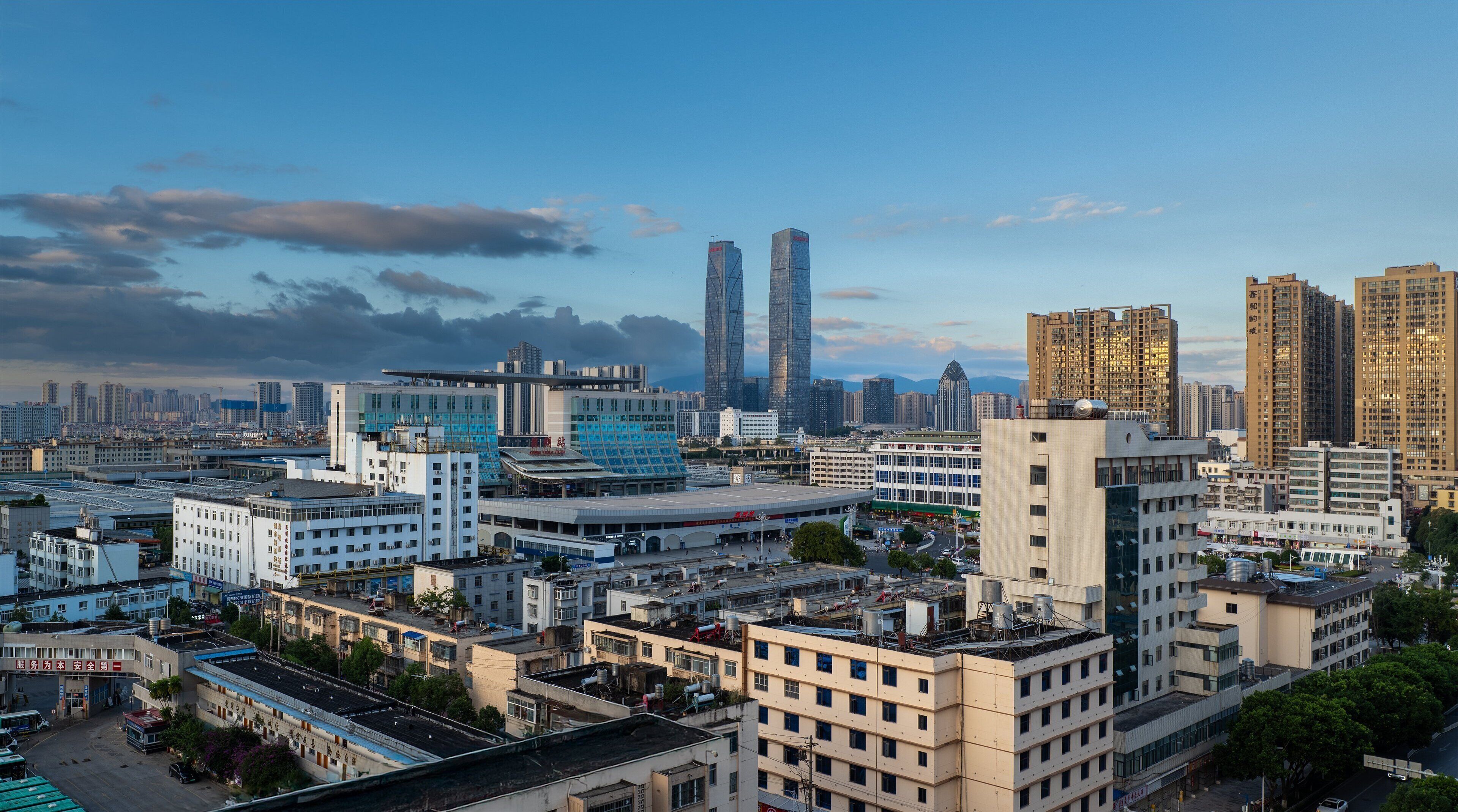 A cityscape with modern high-rise buildings, a mix of commercial and residential structures, and a clear sky.