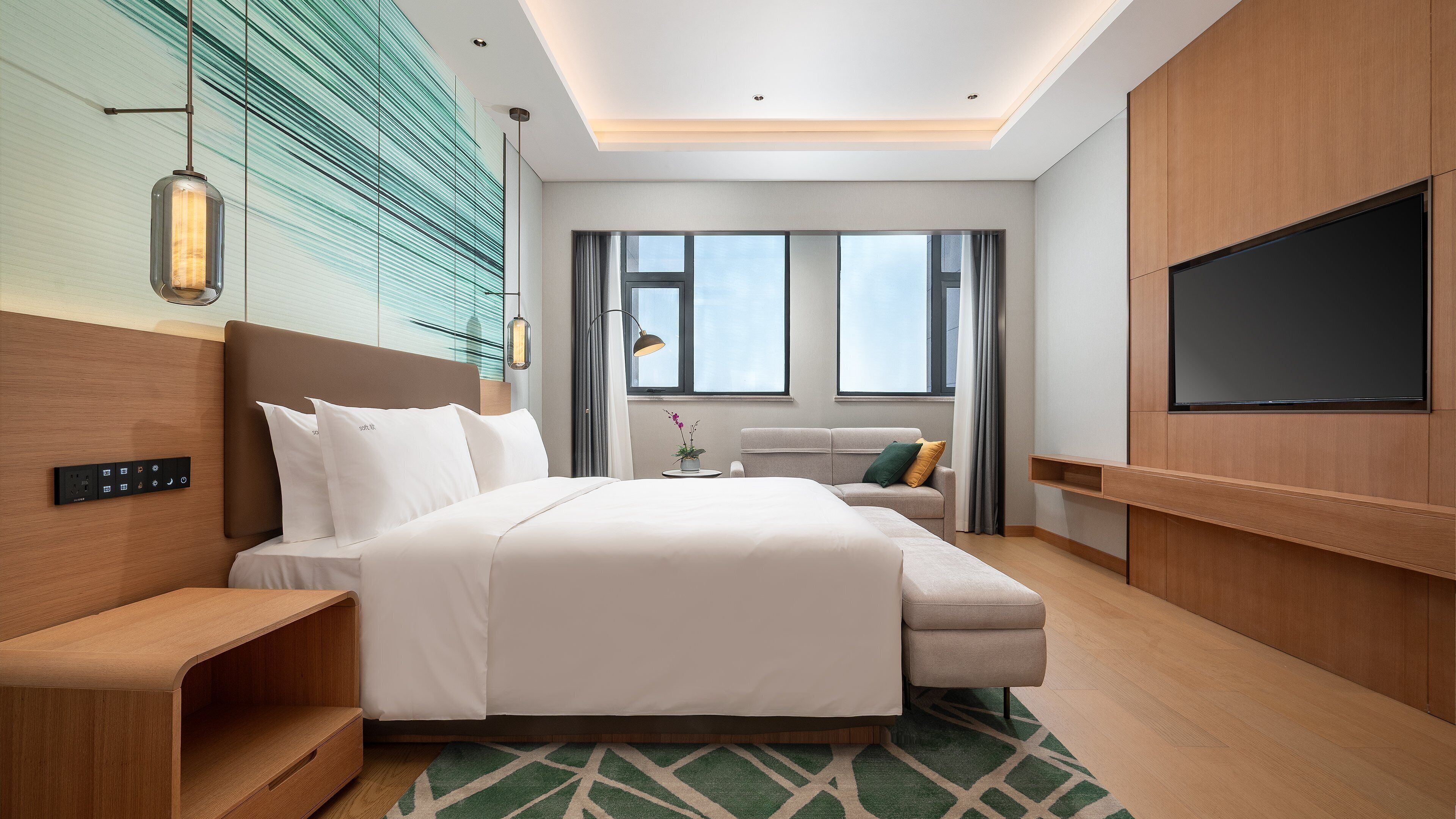 Una habitación de hotel moderna con una cama grande, un sofá, un televisor y un escritorio.