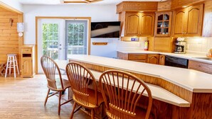 Una cocina moderna con armarios de madera, una isla grande con taburetes de bar y un horno empotrado.