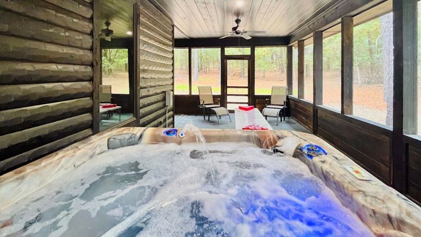 A hot tub with a wooden interior and large windows offering a forest view. - Hot Tub · Detached Game Rm · Pool Table | Dogs OK (Broken Bow)