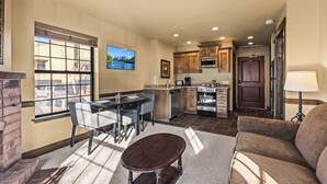 A modern kitchen with a dining area, a fireplace, and a view of the outside.
