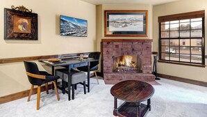 A room with a fireplace, dining table, chairs, and framed pictures on the wall. - 1 block from Park City Mountain with hot tub Managed by Park City Lodging (Park City)