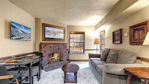 A cozy living room with a fireplace, a dining area, and a sofa. - 1 block from Park City Mountain with hot tub Managed by Park City Lodging (Park City)