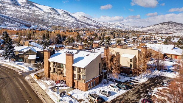A town with buildings, a road, and snow-covered mountains in the background.