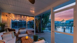 A cozy indoor seating area with a view of a marina at sunset. - Ibis Island Escape (Fort Myers Beach)