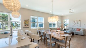 Una cocina amplia con comedor, ventanas grandes y decoración moderna.