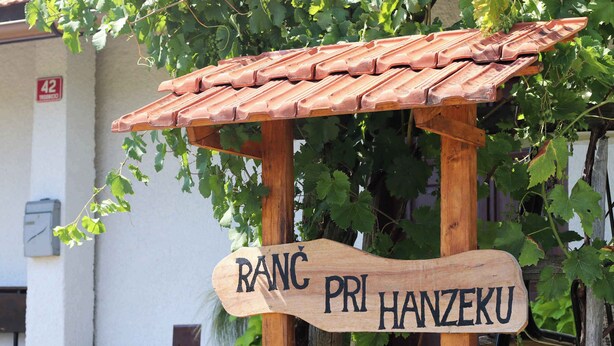A wooden sign with a tiled roof, reading "RANC PRI HANZEKU" against a backdrop of a building and grapevines. - Holiday cottage surrounded by vineyards (Zgornji Leskovec)