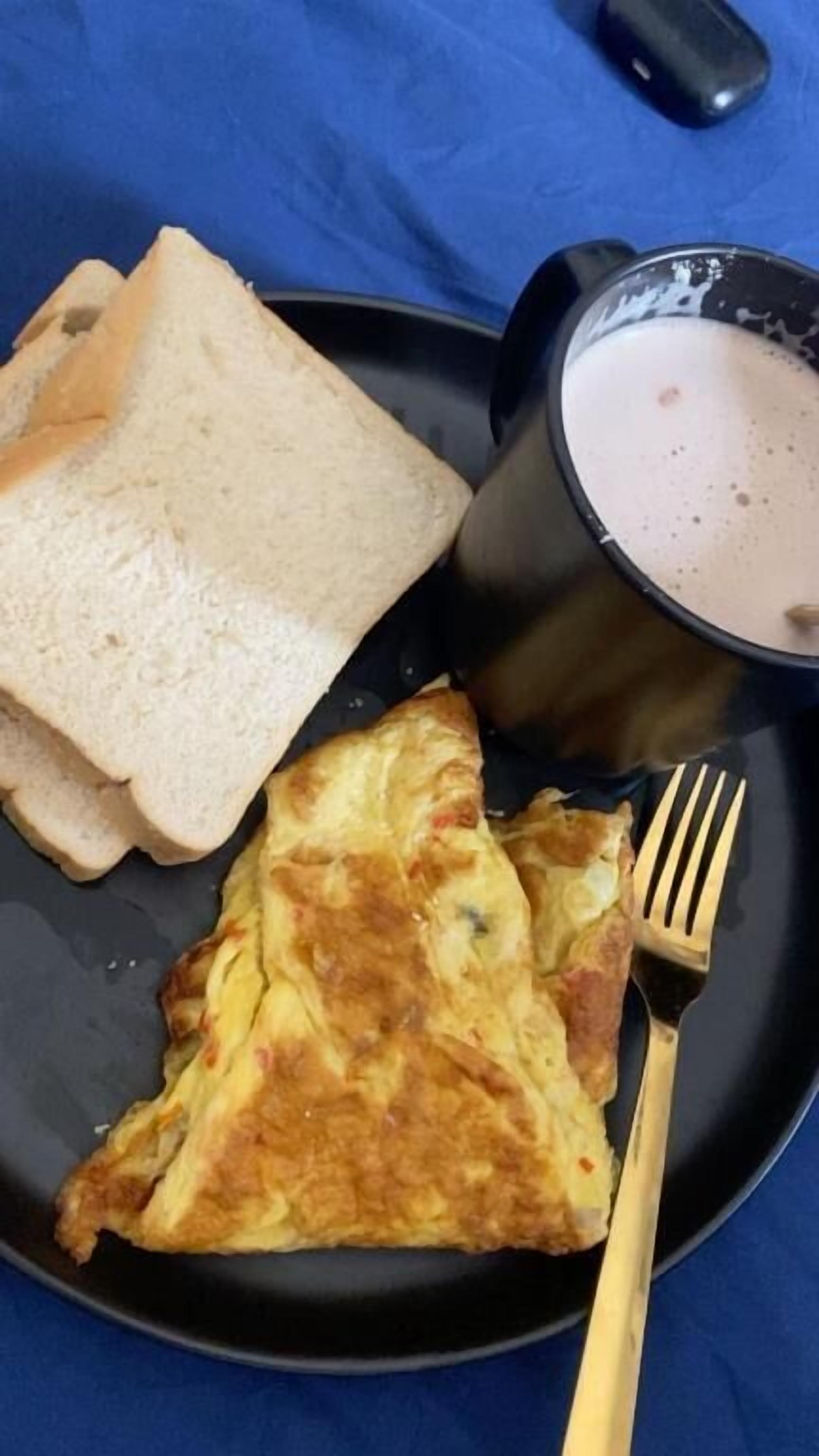 Un plato con tostadas, una porción de tortilla y una taza de café.