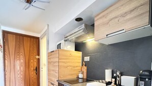 A compact kitchen with wooden cabinetry, a built-in oven, a sink, and a coffee maker. - Alpine stay at the foot of the slopes (Crest-Voland)