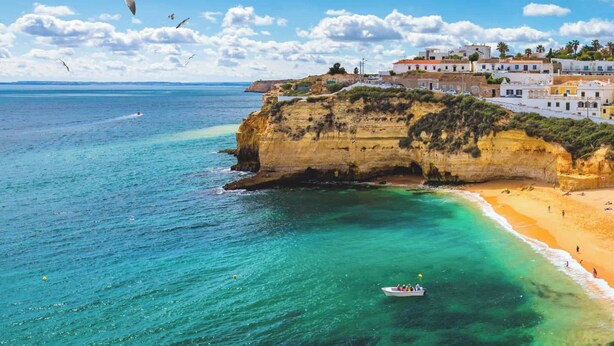 A coastal town with buildings on a cliff overlooking turquoise waters. - Margotia Apartment, Faro, Algarve (Faro)