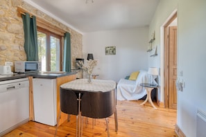 A compact kitchen with a microwave, dishwasher, and a small table with chairs.