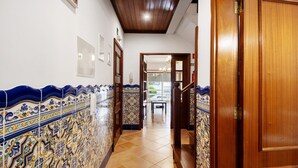 A hallway with tiled walls, wooden doors, and a tiled floor. - Barra Sol - Farol na Praia Apartment with Shared Pool, Balcony, and Wi-Fi (Praia da Barra)