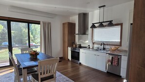 Uma cozinha moderna com área de refeições, grandes janelas e vista para o exterior.